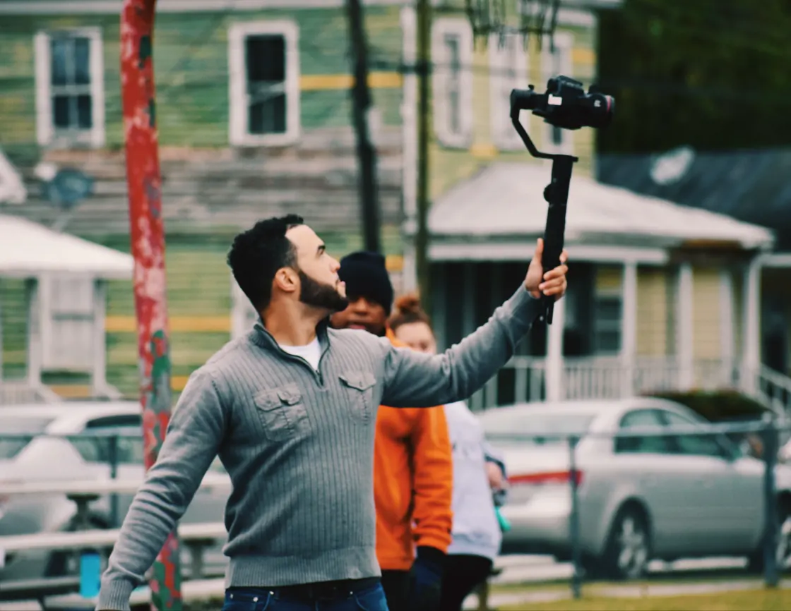 Me reaching up with a gimbal on a street, shooting Dancing in the Park.